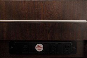 A wooden surface with a metal rod and a power outlet with a red plug-in sign. - Red Roof Inn PLUS+ St Louis - Forest Park/ Hampton Ave  (St. Louis)