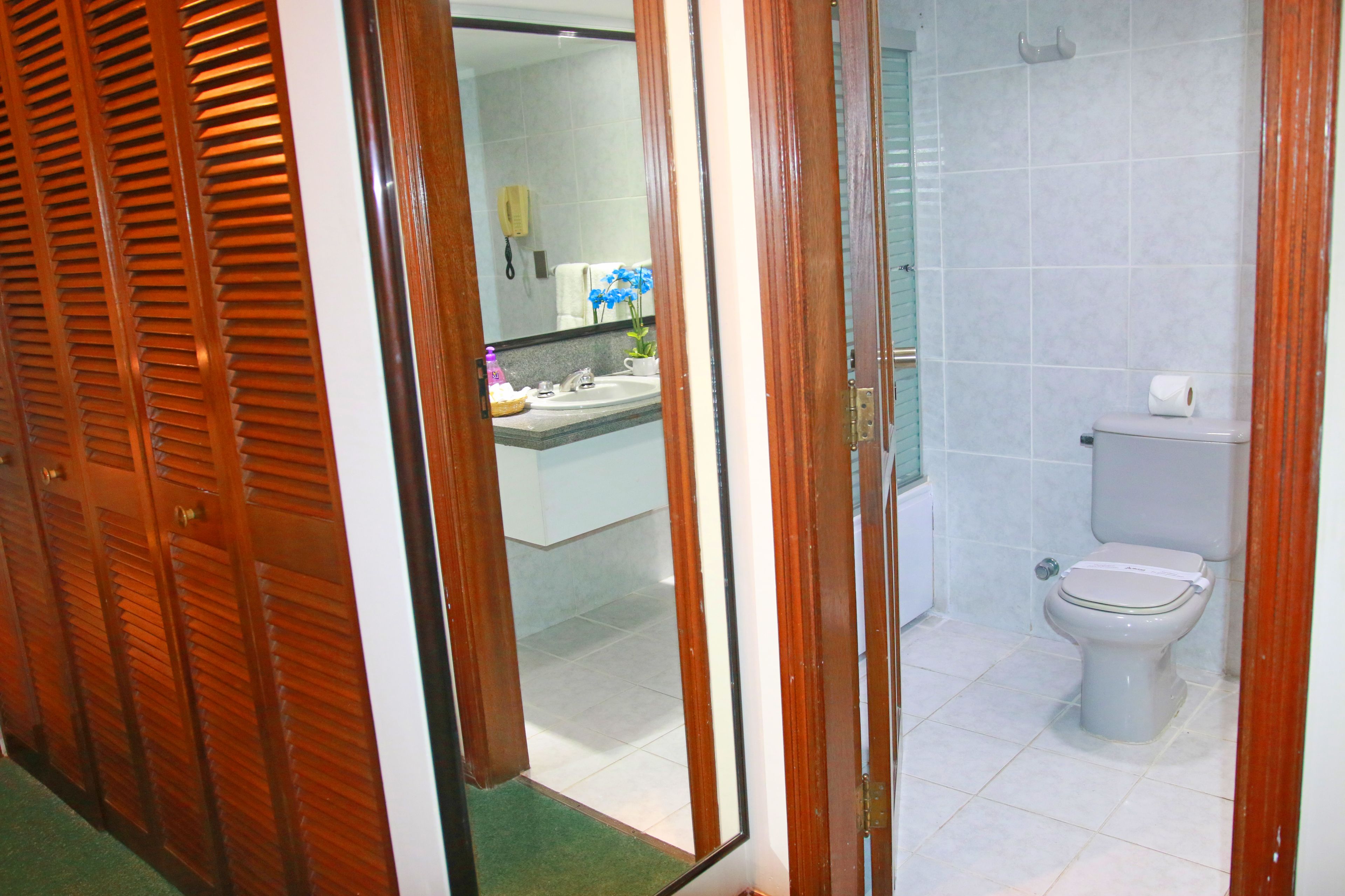 Un baño con inodoro, lavabo y espejo.