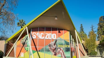 A building with a triangular roof and a large window displaying giraffes.