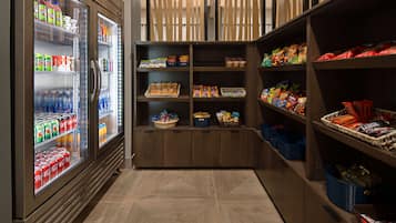 A snack and beverage area with refrigerated drinks, snack bins, and packaged goods.
