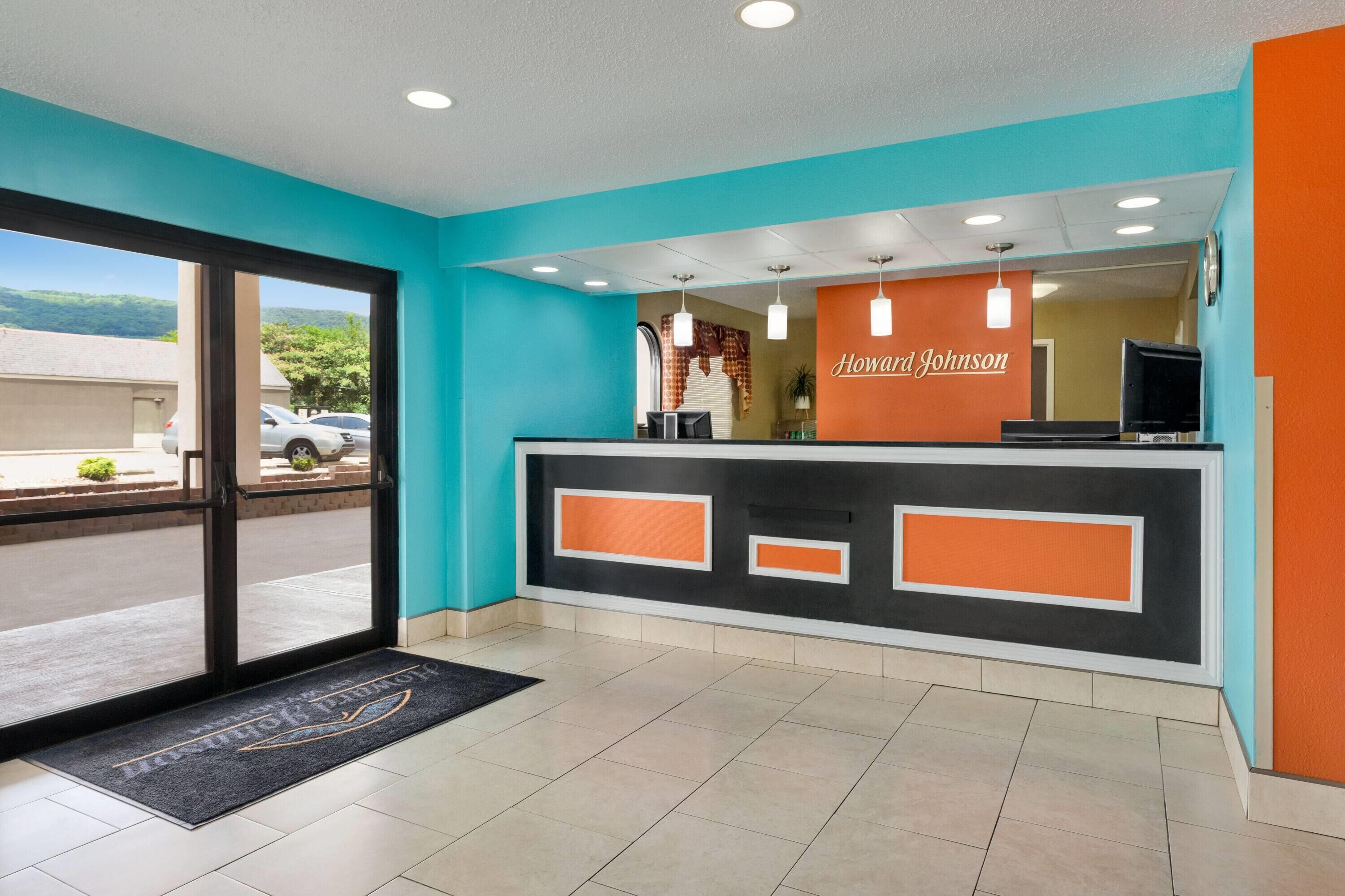 A reception area with a teal and orange color scheme, a glass door entrance, and a nameplate reading 'Howard Johnson.'