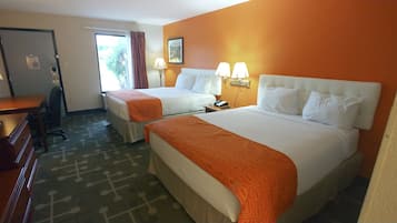 Ein Hotelzimmer mit zwei Betten, einem Schreibtisch und einem Stuhl.
