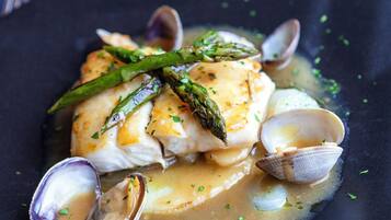 A seafood dish with clams and asparagus on a plate.