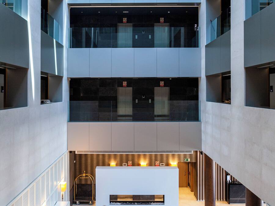 A multi-level atrium with a central seating area, large windows, and modern furnishings.