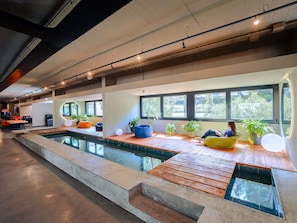 Un'ampia area interna con piscina, zone relax e ampie finestre.