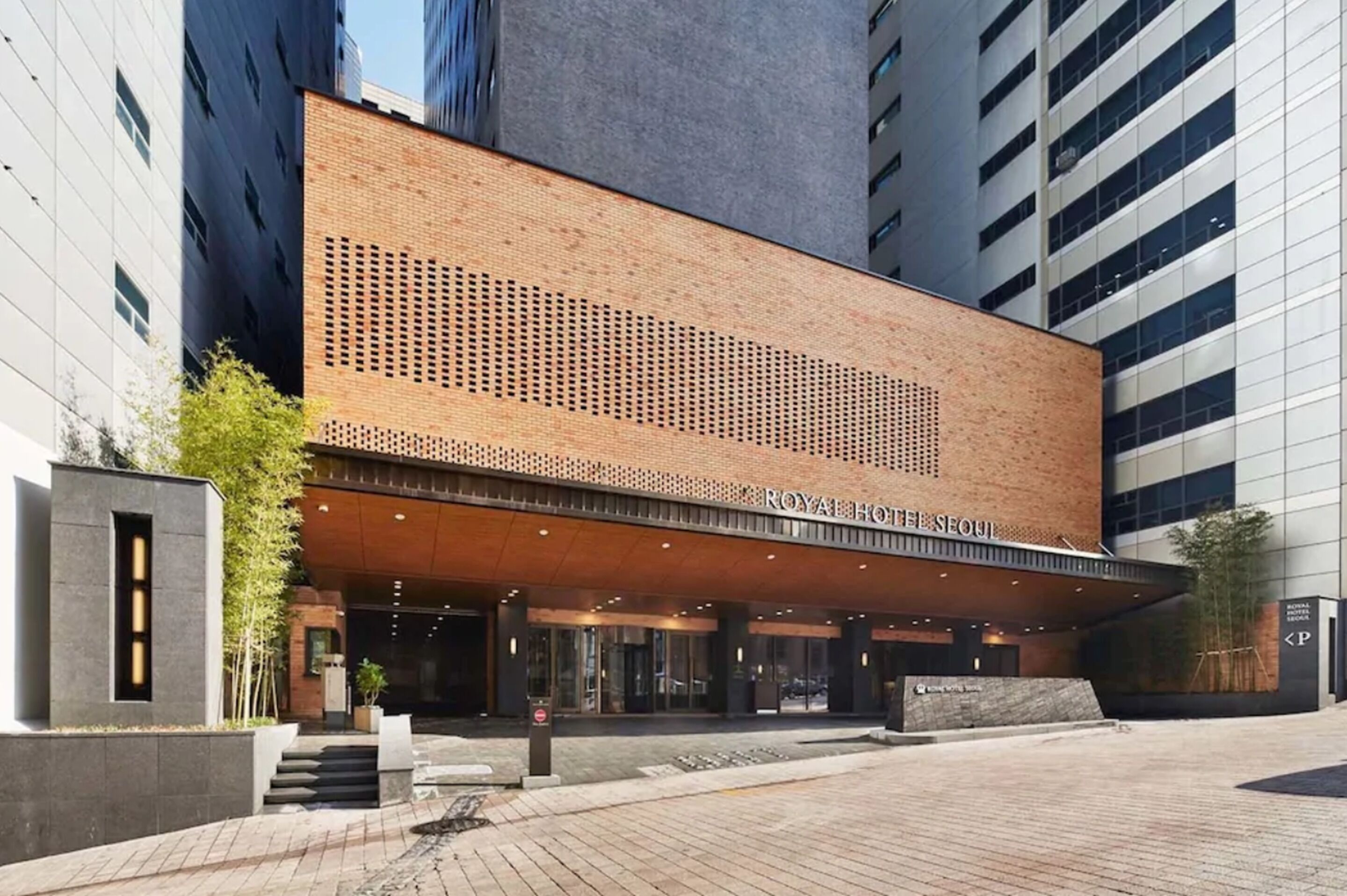 Un hotel moderno con una fachada de ladrillo llamativa y una entrada amplia.