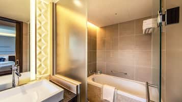 A modern bathroom with a large sink, a bathtub, and a shower area.