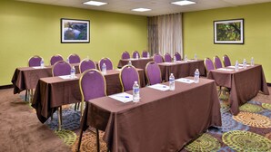A conference room with multiple tables, chairs, and water bottles, featuring a patterned carpet and green walls. - Holiday Inn Express Hunt Valley by IHG (Hunt Valley)