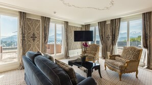 A spacious living room with a large sofa, a patterned armchair, and a flat-screen TV. - Chateau Guetsch (Lucerne)