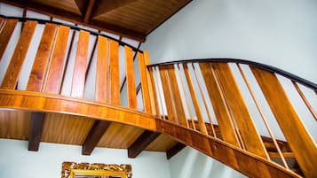 A wooden spiral staircase with a dark handrail and wooden steps.