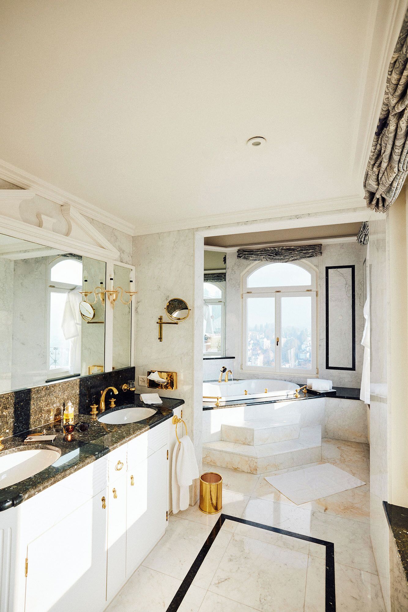 Une salle de bain luxueuse dotée d’un grand meuble-lavabo, d’un lavabo séparé et d’une baignoire.