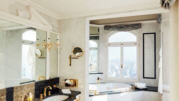 Une salle de bain luxueuse dotée d’un grand meuble-lavabo, d’un lavabo séparé et d’une baignoire.