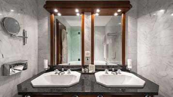 A bathroom with two sinks, a mirror, and a towel rack.