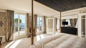 A spacious bedroom with a large bed, a television, and a balcony with a view. - Chateau Guetsch (Lucerne)