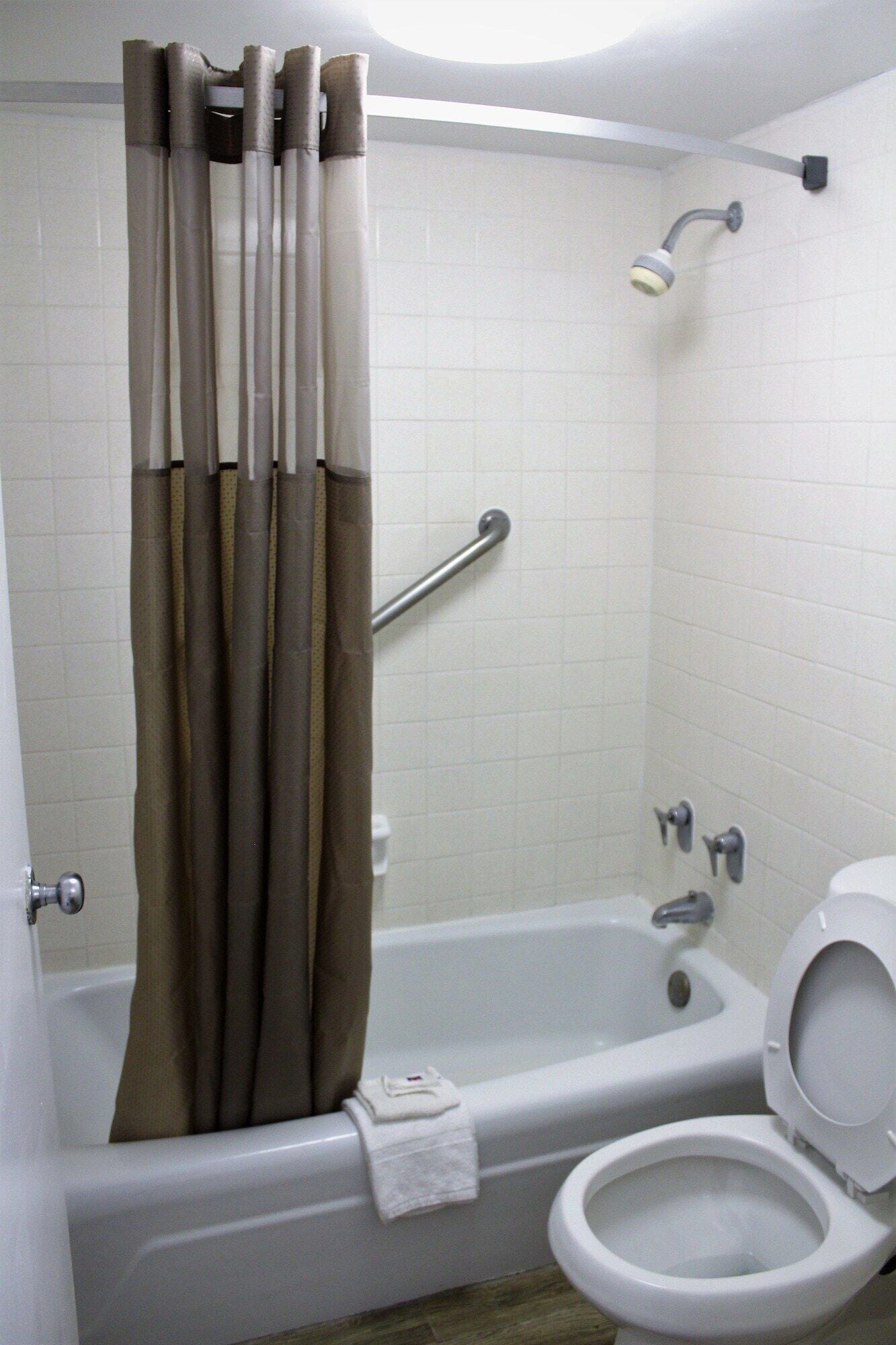 A bathroom with a bathtub, toilet, and shower.