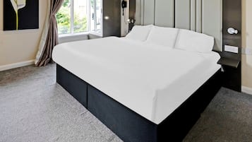 Tabla de planchar con plancha y ropa de cama