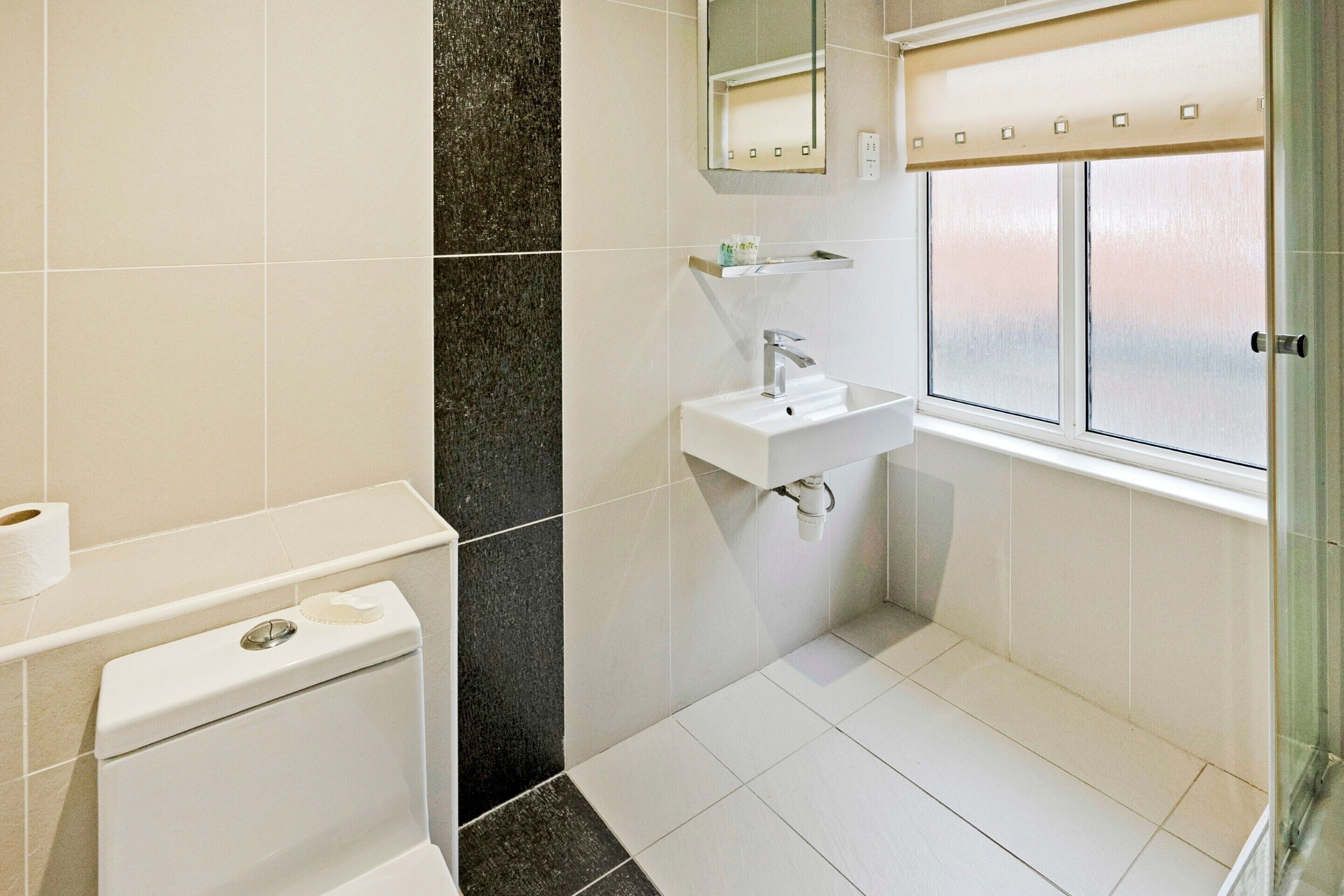 A modern bathroom with a toilet, sink, and shower area.