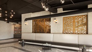 A modern lobby with a seating area, patterned floor, and decorative lighting.