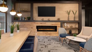 A modern living room with a fireplace, a flat-screen TV, and comfortable seating.