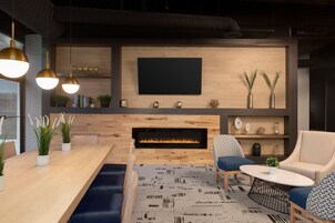Una sala de estar moderna con chimenea, televisor de pantalla plana y asientos cómodos.