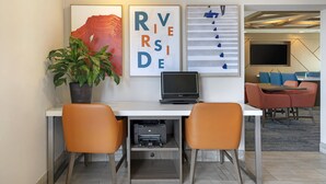 A modern office space with a desk, two chairs, a laptop, a printer, and a potted plant. - Holiday Inn Express San Bernardino - Colton by IHG (Colton)