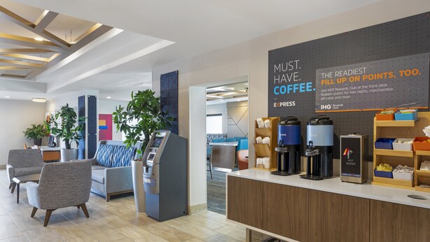 A modern reception area with a coffee station, seating, and a sign promoting a rewards program.