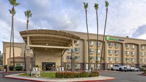 A Holiday Inn Express hotel with a covered entrance, palm trees, and a parking lot. - Holiday Inn Express San Bernardino - Colton by IHG (Colton)