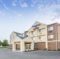 Un hotel Fairfield Inn & Suites by Marriott con un diseño moderno, que cuenta con una entrada central, varias ventanas y un estacionamiento.