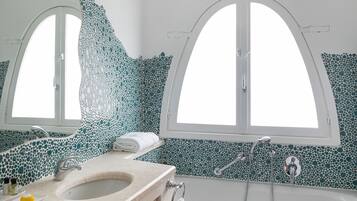 A bathroom with a freestanding bathtub, a vanity with a sink, and a large mirror.