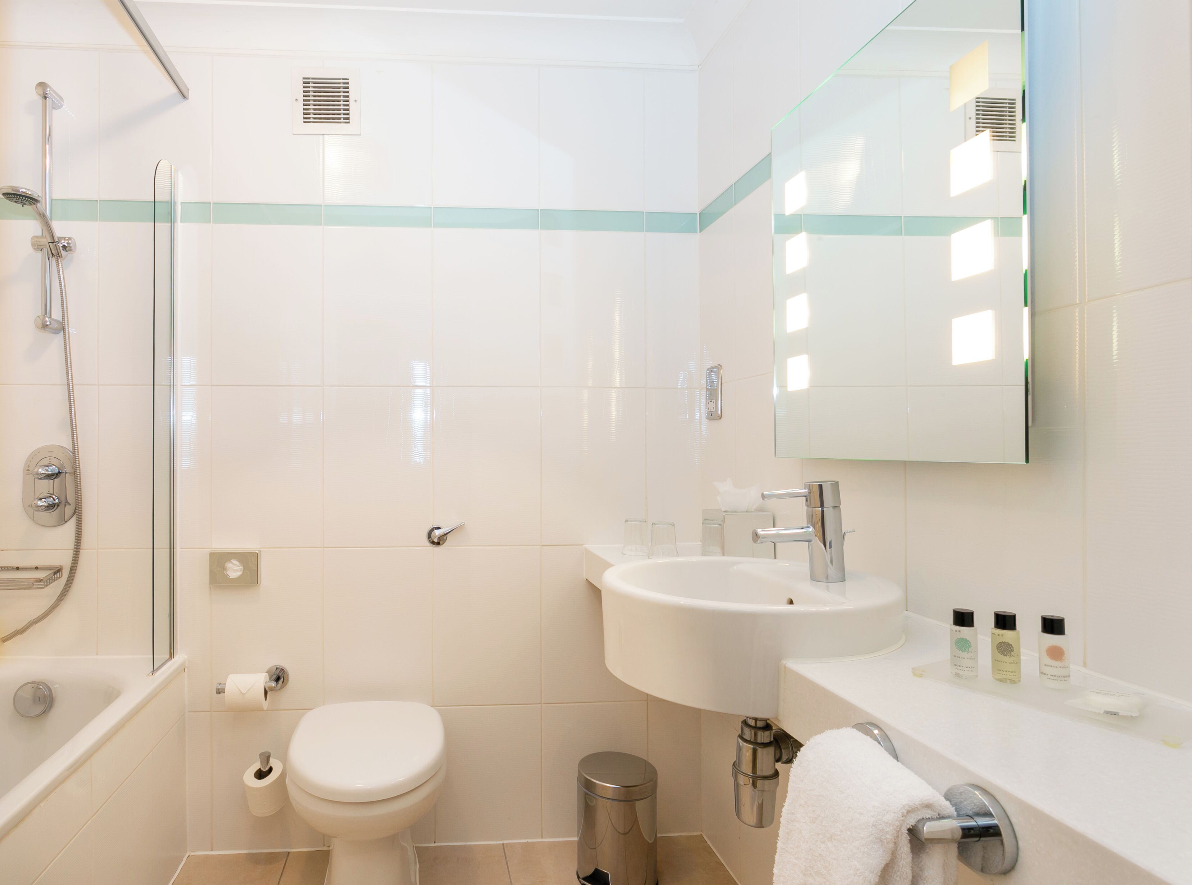 A modern bathroom with a bathtub, toilet, sink, and a mirror.