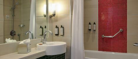 A bathroom with a sink, mirror, shower, and bathtub.