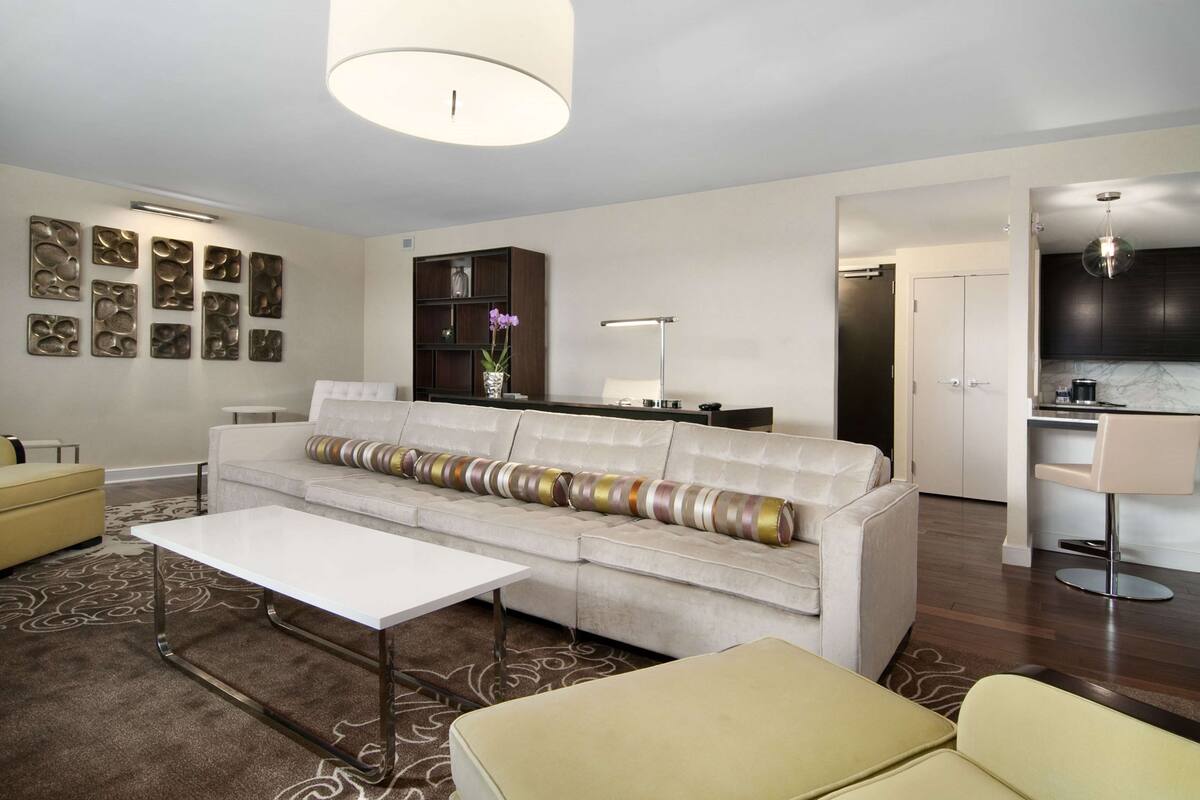 Una sala de estar moderna con un sofá blanco, una mesa de centro y una estantería.