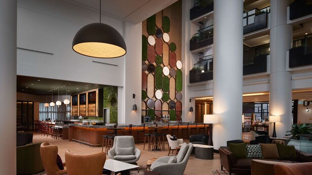 Eine großzügige Lobby mit Barbereich, Sitzgelegenheiten und einer Wand mit kreisförmigen Mustern.