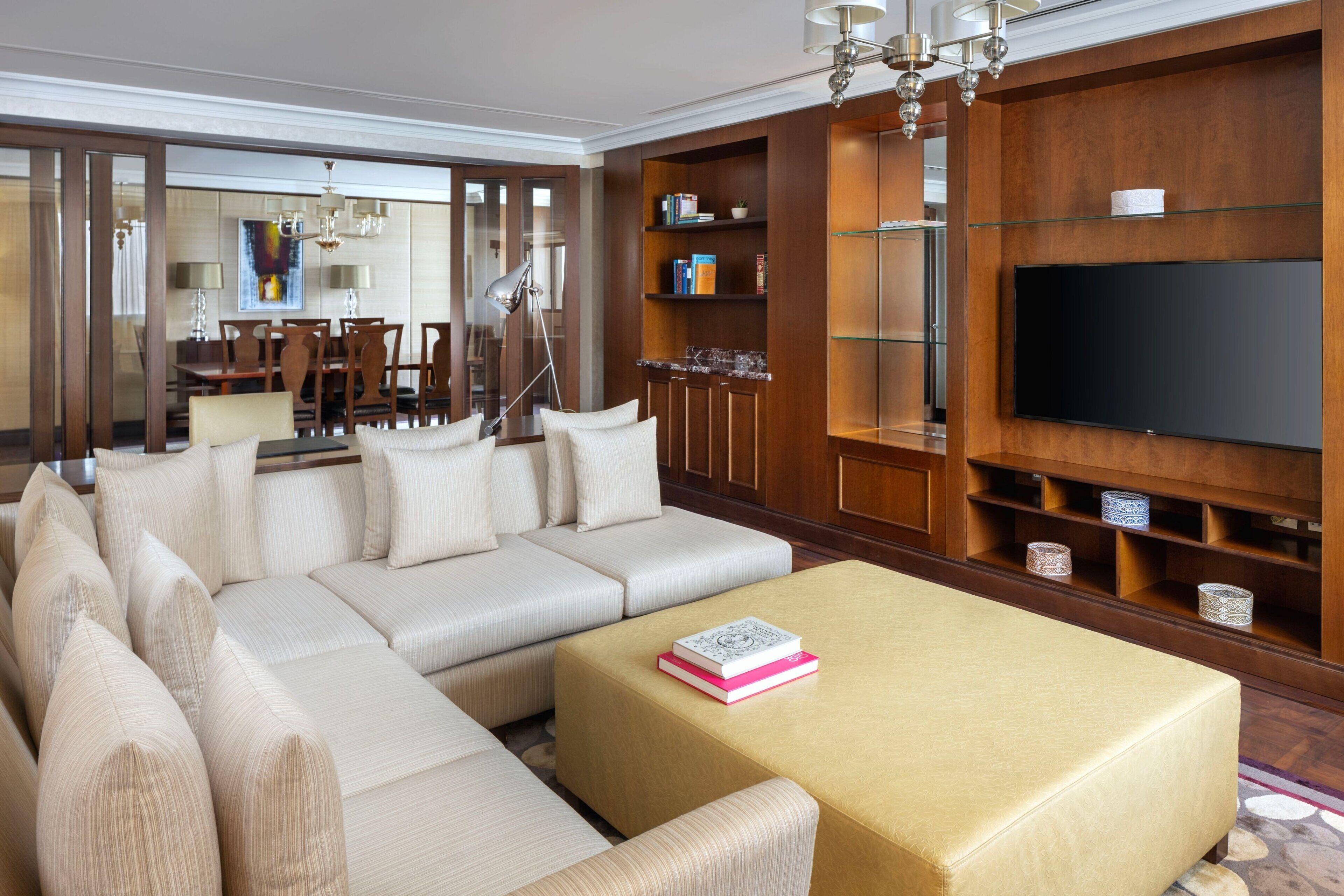 Ein modernes Wohnzimmer mit einer Eckcouch, einem Couchtisch und einer TV-Wand.