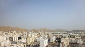 A cityscape with numerous buildings, roads, and a mountainous backdrop.
