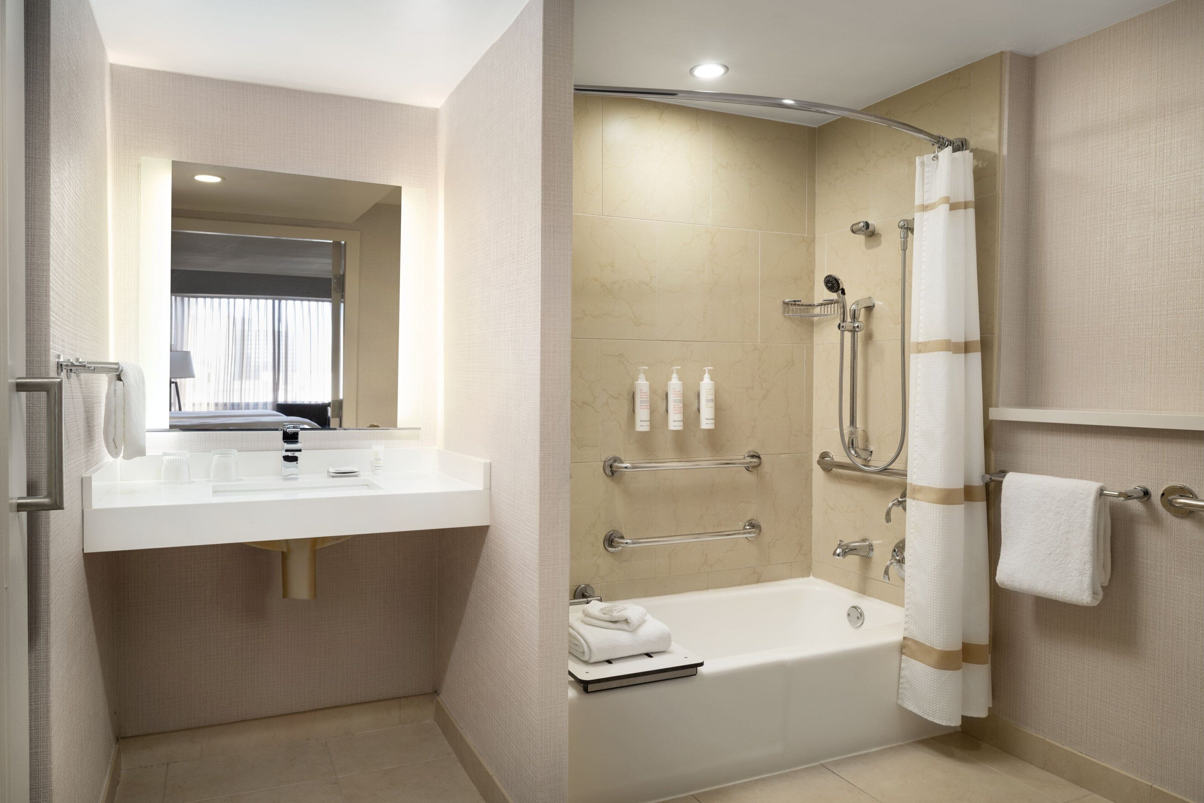 A modern bathroom with a bathtub, shower, and vanity.