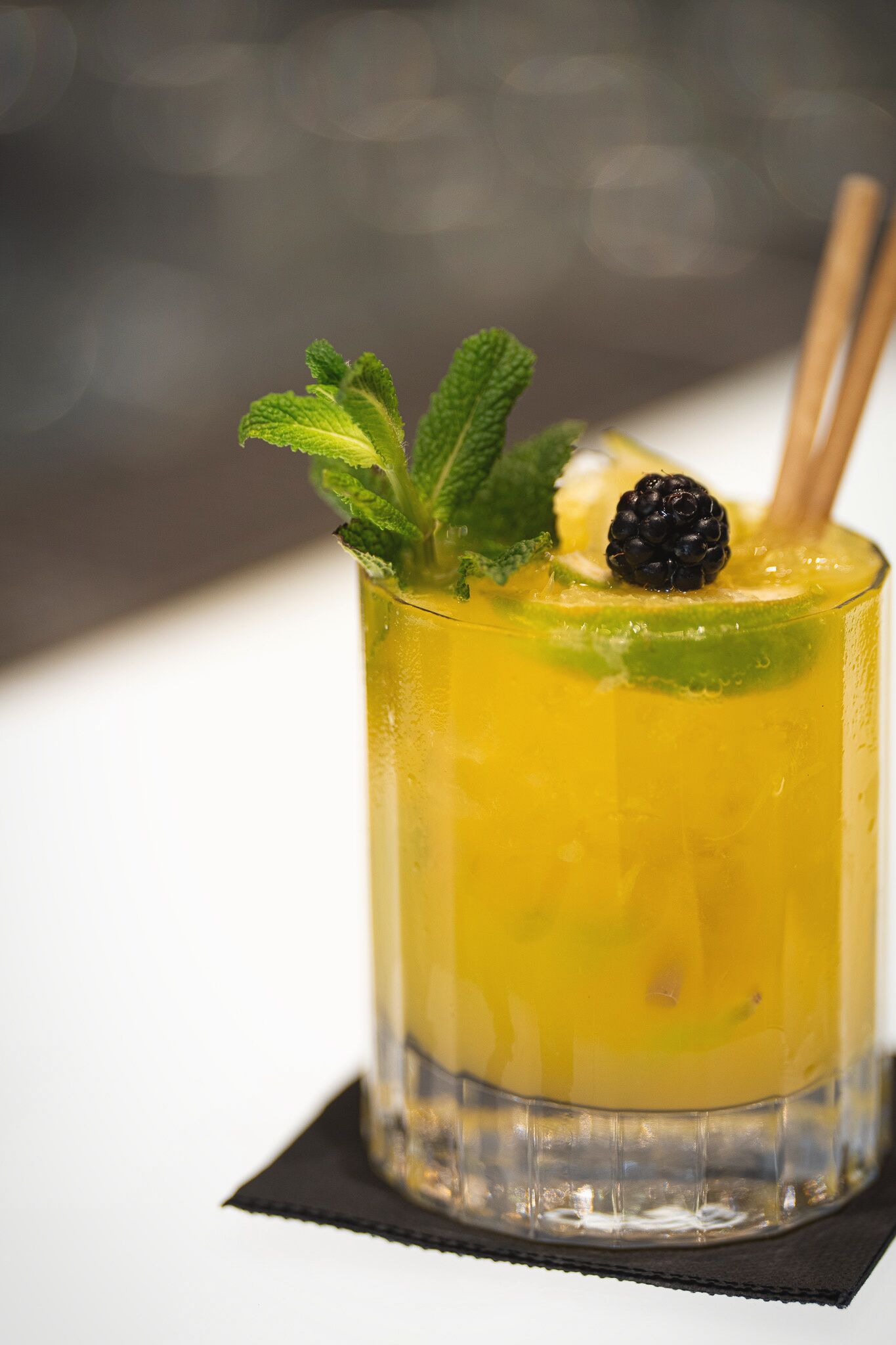 Um cocktail com uma fatia de limão e folhas de hortelã.
