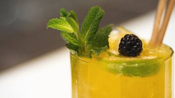 Um cocktail com uma fatia de limão e folhas de hortelã.