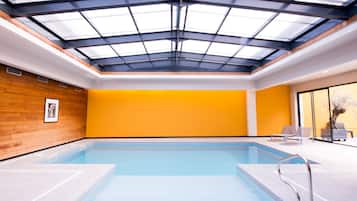 Een binnenzwembad en ligstoelen