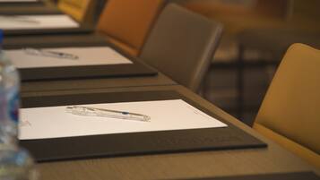 A conference room with a long table, chairs, and documents.