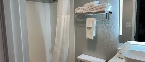 Ein Badezimmer mit Badewanne, Toilette und Waschbecken mit Spiegel.