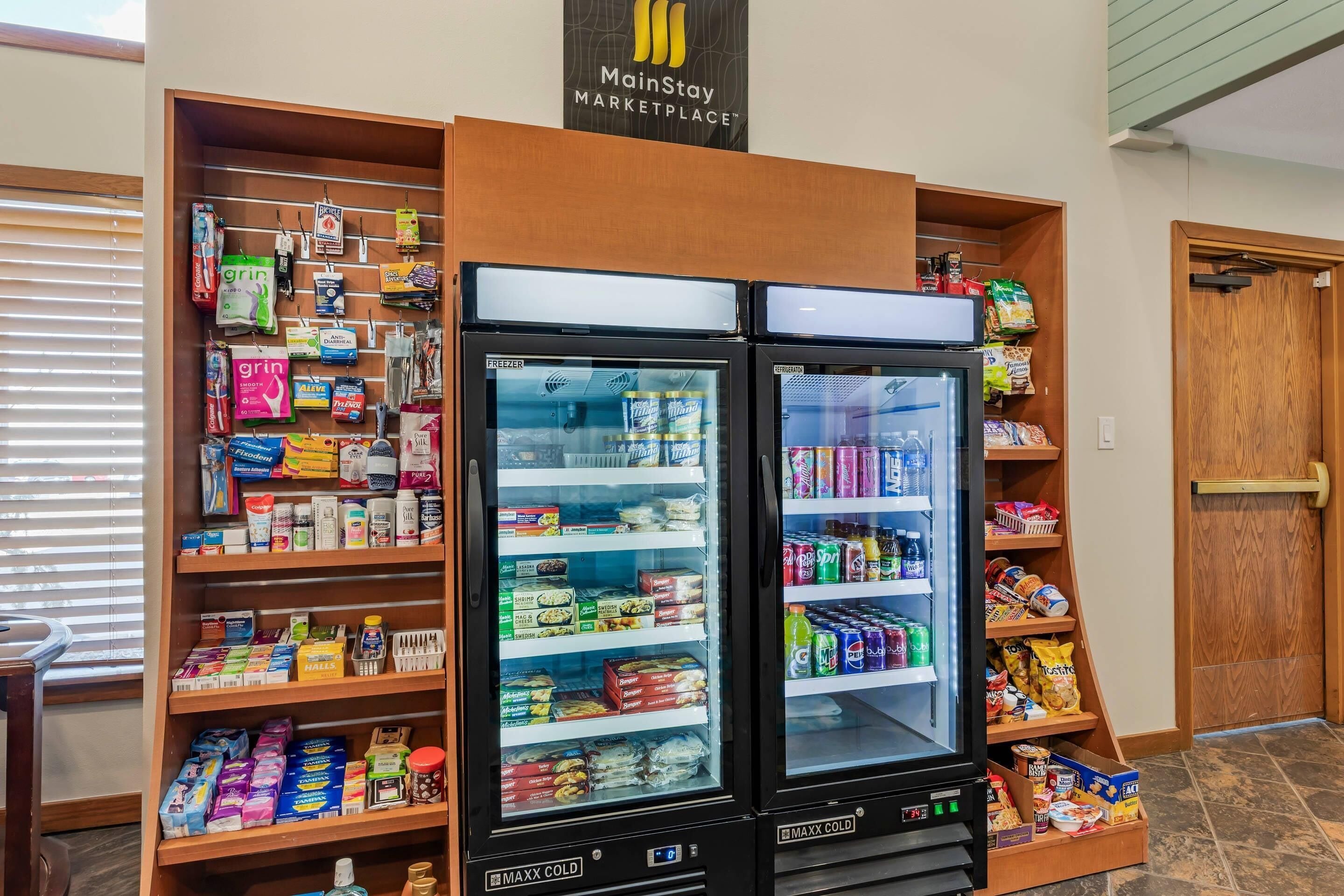 A MainStay Marketplace with two MAXX Cold refrigerators stocked with snacks, drinks, and other items.