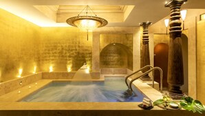 A spa area with a large hot tub, wooden columns, and a decorative ceiling light. - Hotel Metropole Venezia (Venice)