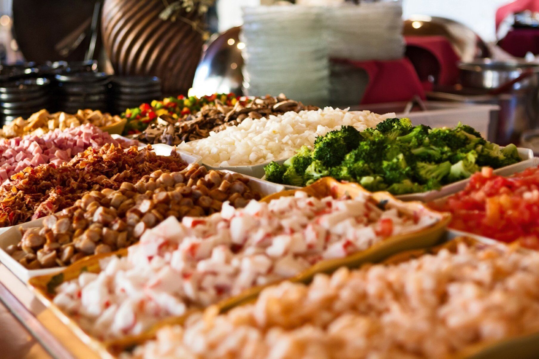 Buffet com diversas opções de comida, incluindo arroz, brócolis e diferentes tipos de carne.
