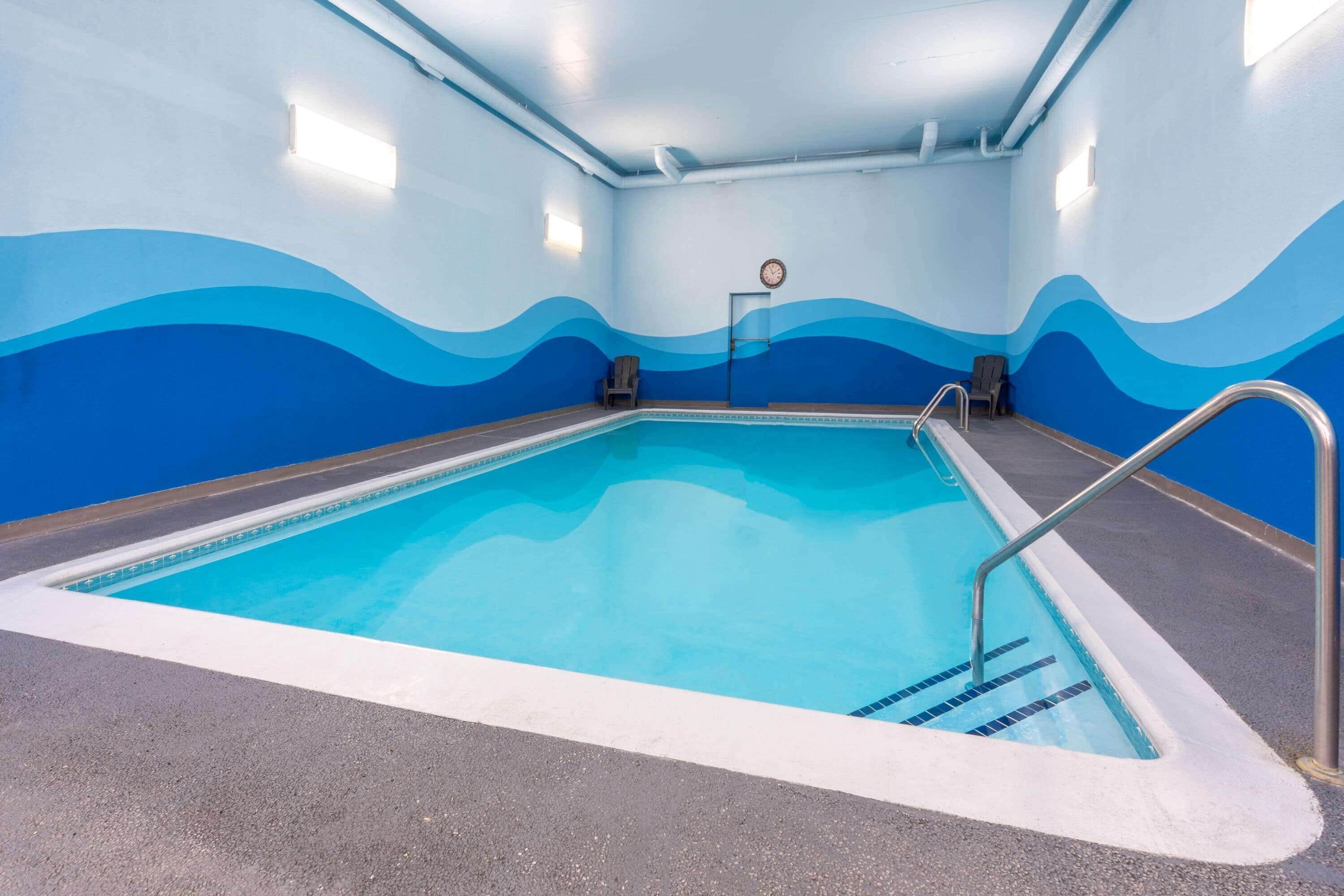 Ein Innenpool mit wellenmustertausgekleideten Wänden und einer Uhr an der Wand.