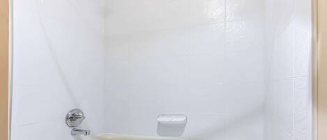 Un baño con bañera, ducha y jabonera.