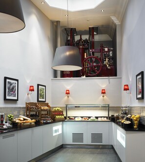 Una cocina moderna con una parrilla integrada, una presentación de frutas y una estación de café.