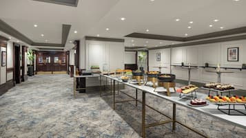 A spacious room with a long buffet table displaying various food items.