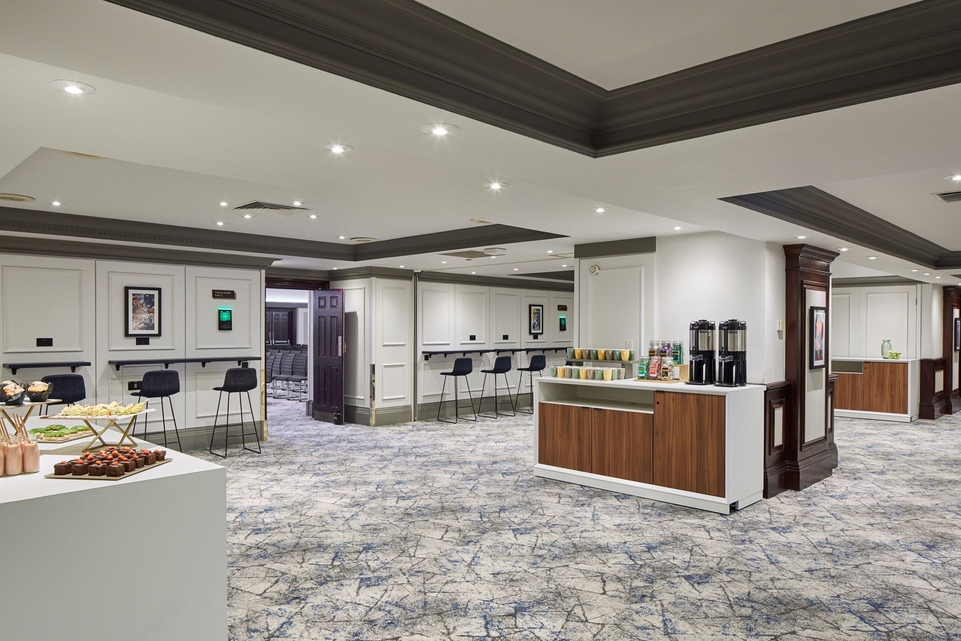 A spacious hotel lobby with a bar area, seating arrangements, and a reception desk.