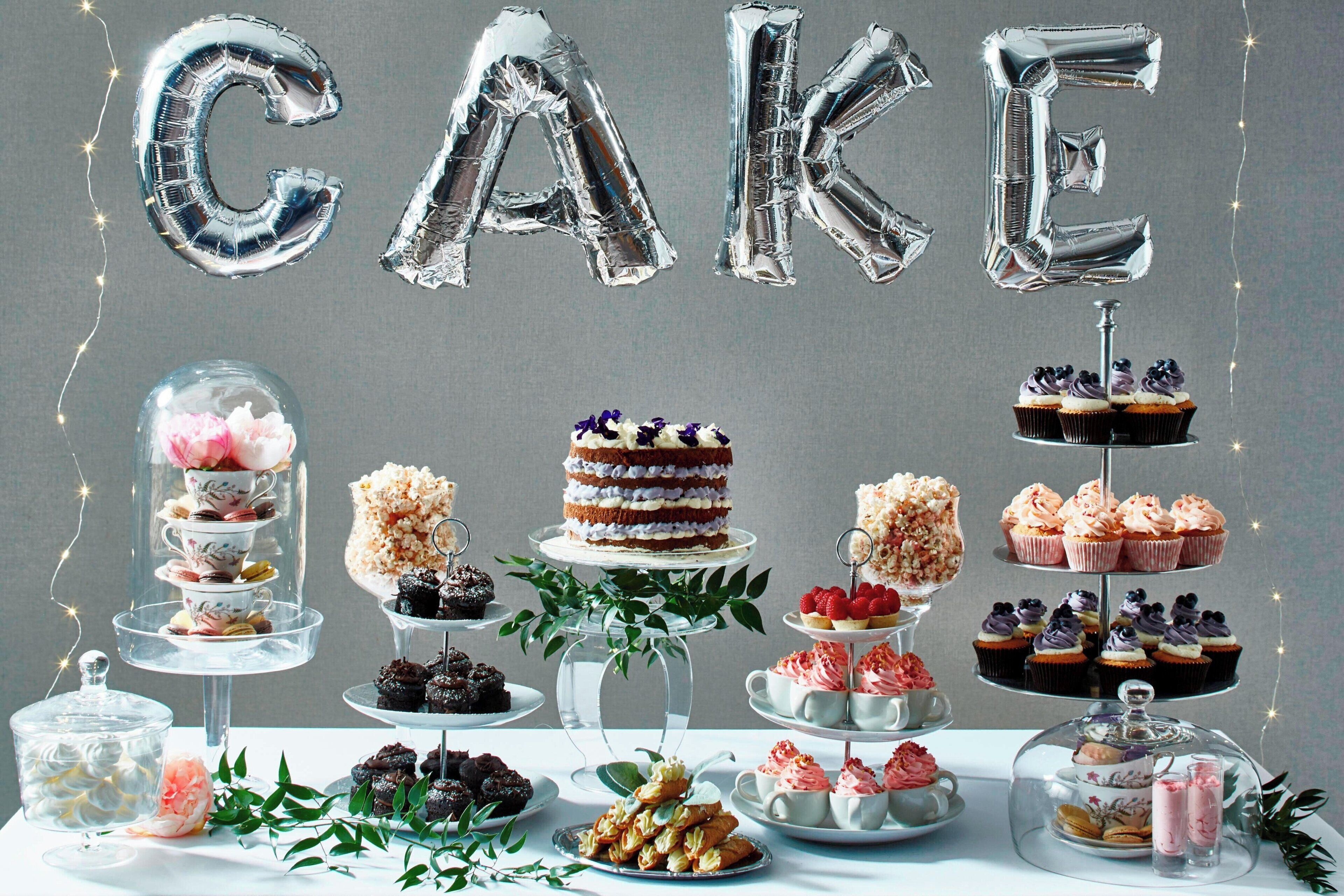 A dessert display with various cakes and pastries, including a layered cake with a cherry on top.